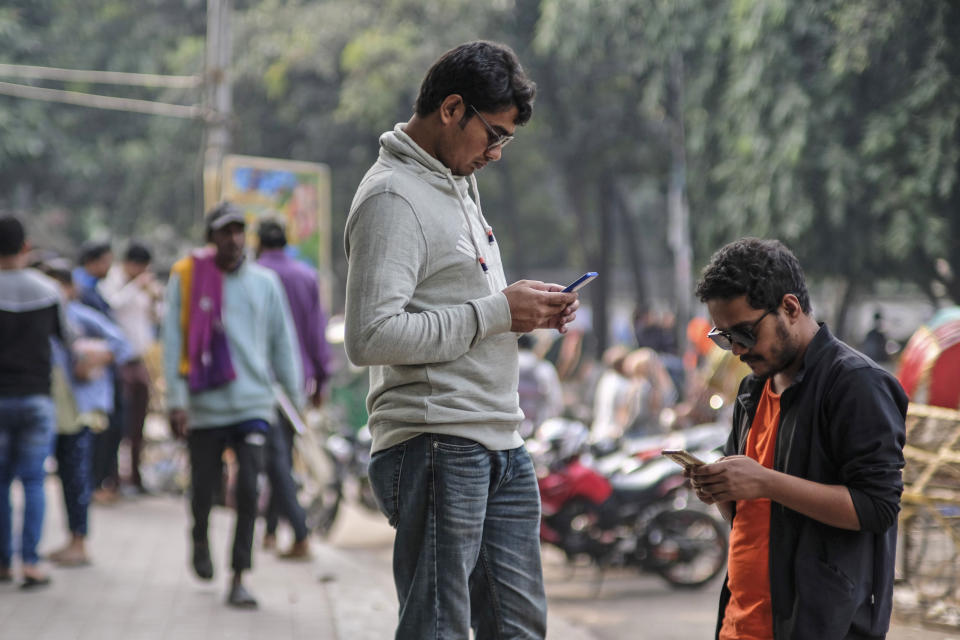 FILE - People engage with their mobile phones at Dhaka University area, Bangladesh, Dec.21, 2023. Artificial intelligence is supercharging the threat of election disinformation worldwide, making it easy for anyone to create fake – but convincing – content aimed at fooling voters. People in countries with low literacy rates, such as Bangladesh and India, are especially vulnerable to social media misinformation. (AP Photo/Mahmud Hossain Opu, File)