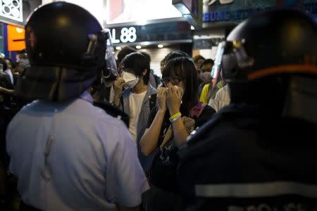 A pro-democracy protester cries in front of riot police during scuffle on a blocked road at Mongkok shopping district in Hong Kong October 17, 2014. REUTERS/Tyrone Siu