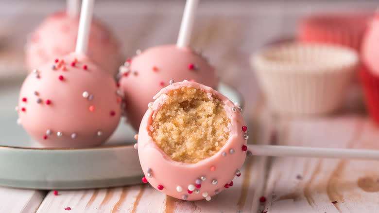 Cake pops with pink icing and silver, white, and red sprinkles
