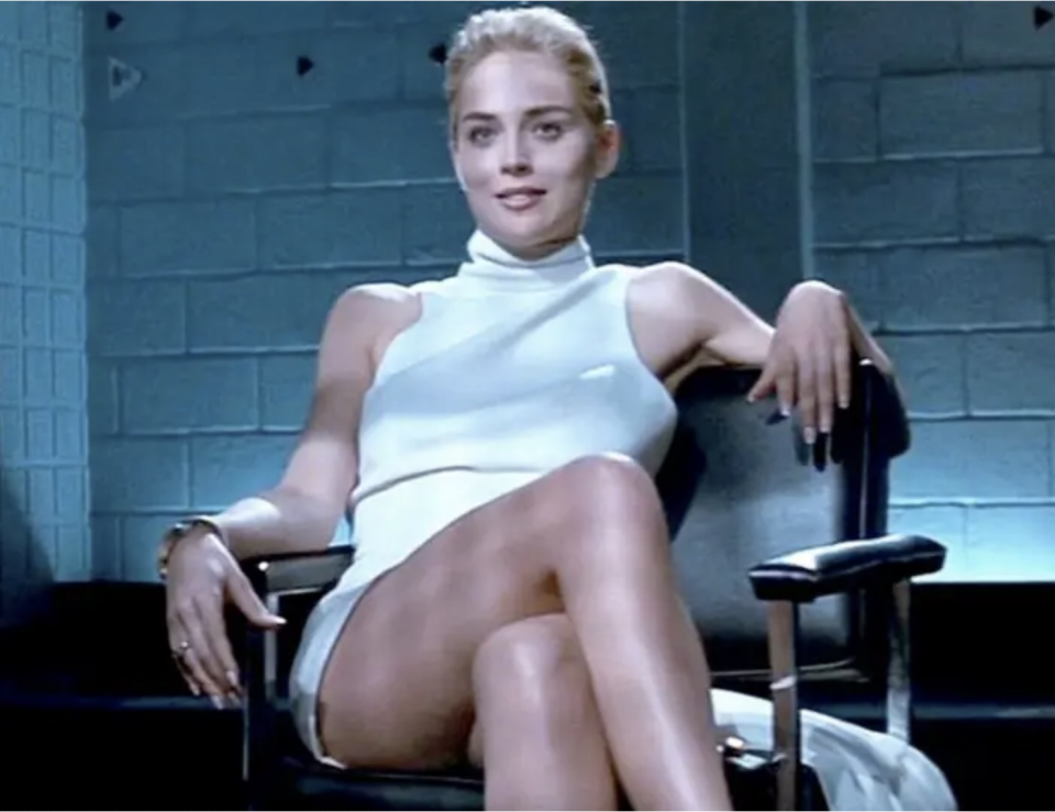 Screenshot from "Basic Instinct" of her sitting cross legged in the chair