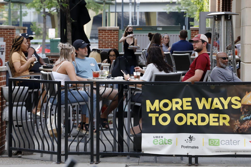 FILE—This file photo from June 28, 2020 shows people gathering at tables outside Bar Louie in Pittsburgh. Pennsylvania is imposing broad new statewide restrictions on bars and restaurants and larger indoor gatherings, with Gov. Tom Wolf citing an "alarming escalation" in new coronavirus infections on Wednesday, July, 15, 2020. (AP Photo/Gene J. Puskar, File)