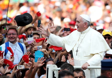 Pope Francis tries to take a cap as he arrives to lead a special audience for members of the Renewal in the Holy Spirit movement in Saint Peter's square at the Vatican July 3, 2015. REUTERS/Alessandro Bianchi