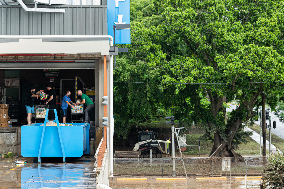 Woolworths employees dump flood-damaged food in Maryborough, 220 km north of Brisbane, on January 11, 2022. 