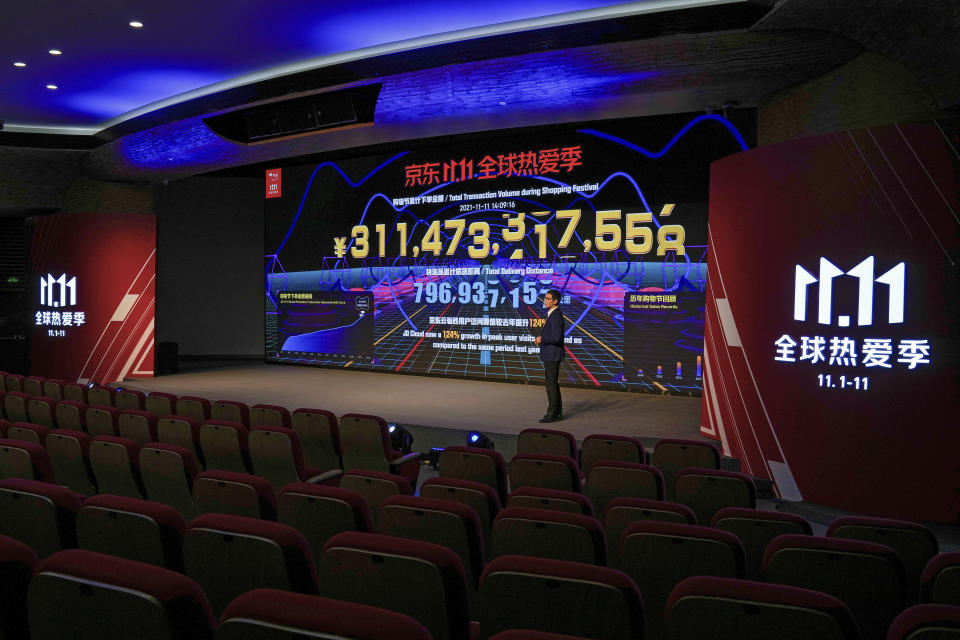 CORRECTS THE TITLE OF LIU HUI - Liu Hui, Director of JD Consumption and Industrial Development Research Institute, speaks in front of a display showing live sales figures for China's biggest online shopping day, known as "Singles' Day" at an empty hall of the headquarters of online retailer JD.com in Beijing, Thursday, Nov. 11, 2021. China's biggest online shopping day, known as "Singles' Day" on Nov. 11, is taking on a muted tone this year as regulators crack down on the technology industry and President Xi Jinping pushes for "common prosperity." (AP Photo/Andy Wong)