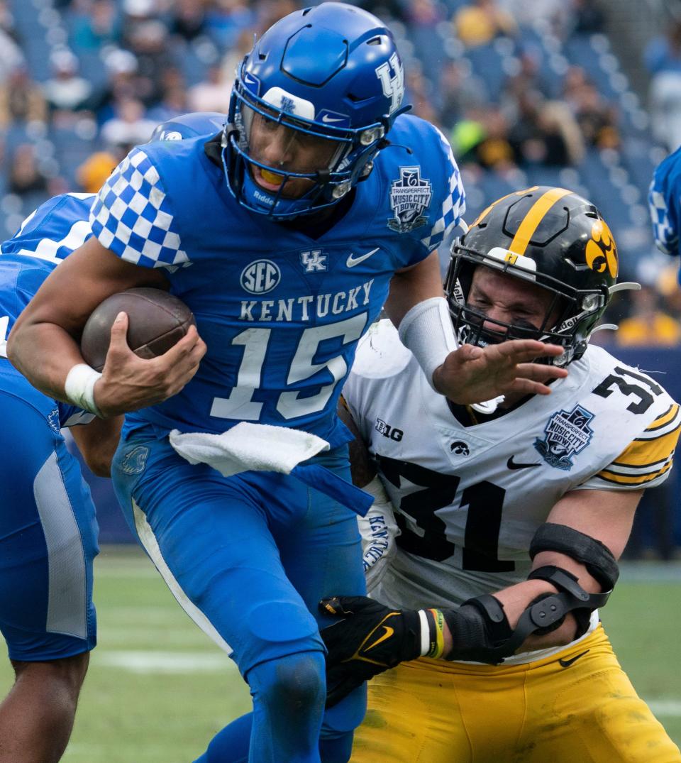 Kentucky quarterback Destin Wade spins away from Iowa linebacker Jack Campbell during the second quarter of the TransPerfect Music City Bowl at Nissan Stadium, Dec. 31, 2022, in Nashville, Tenn.