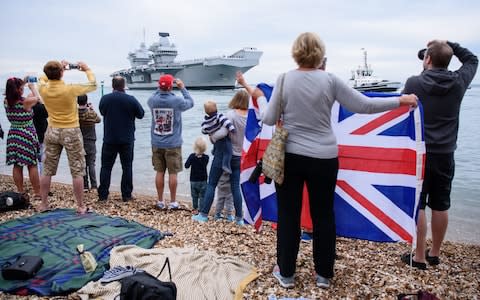 Members of the public gather to witness the arrival of the HMS Queen Elizabeth  - Credit: Leon Neal/Getty