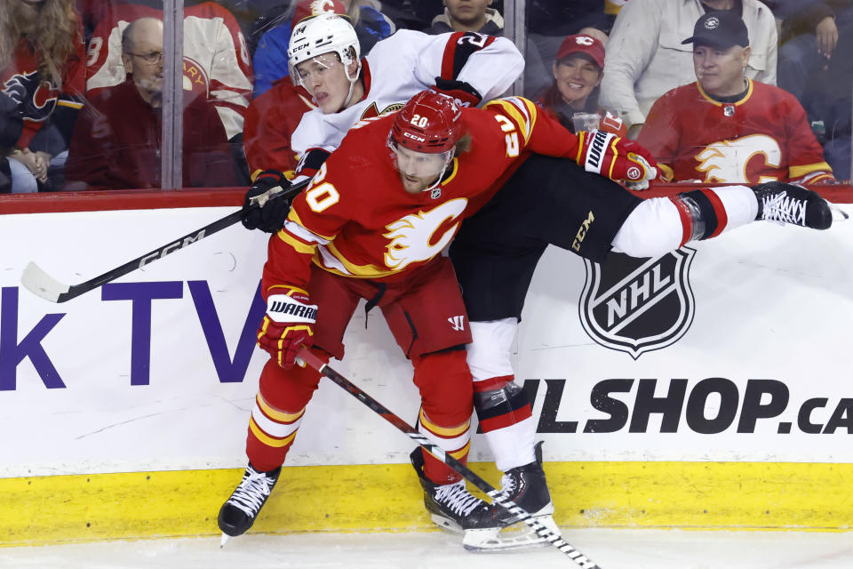 Calgary Flames' Blake Coleman (20) hits Ottawa Senators' Jacob Bernard-Docker during the first period of an NHL hockey game Tuesday, Jan. 9, 2024, in Calgary, Alberta. (Larry MacDougal/The Canadian Press via AP)