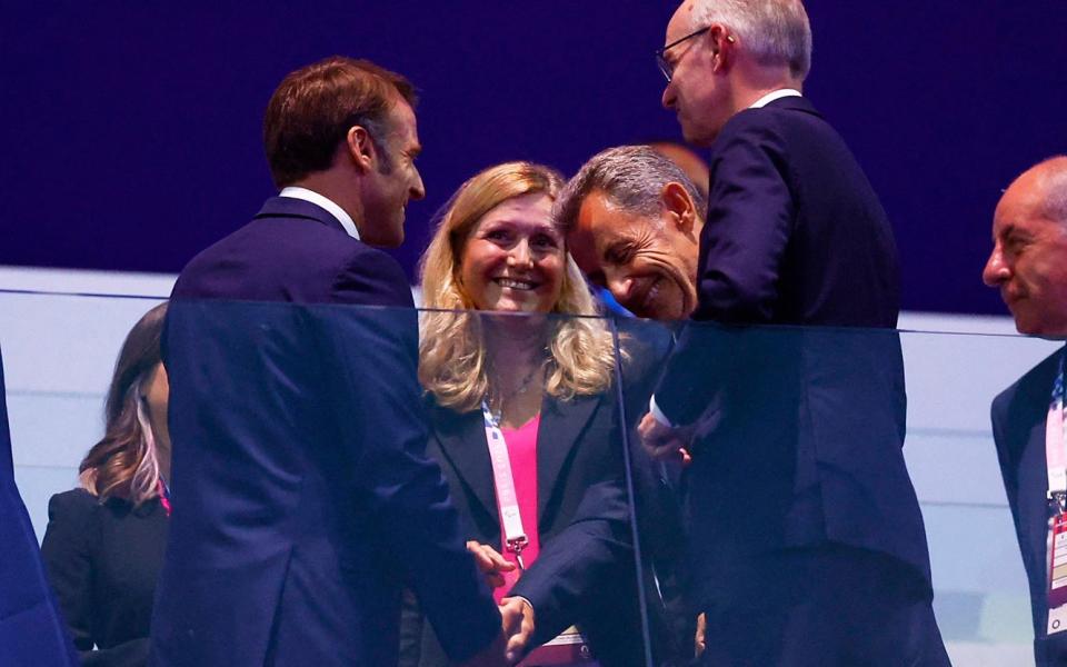 Nicolas Sarkozy and Emmanuel Macron shake hands at the closing ceremony