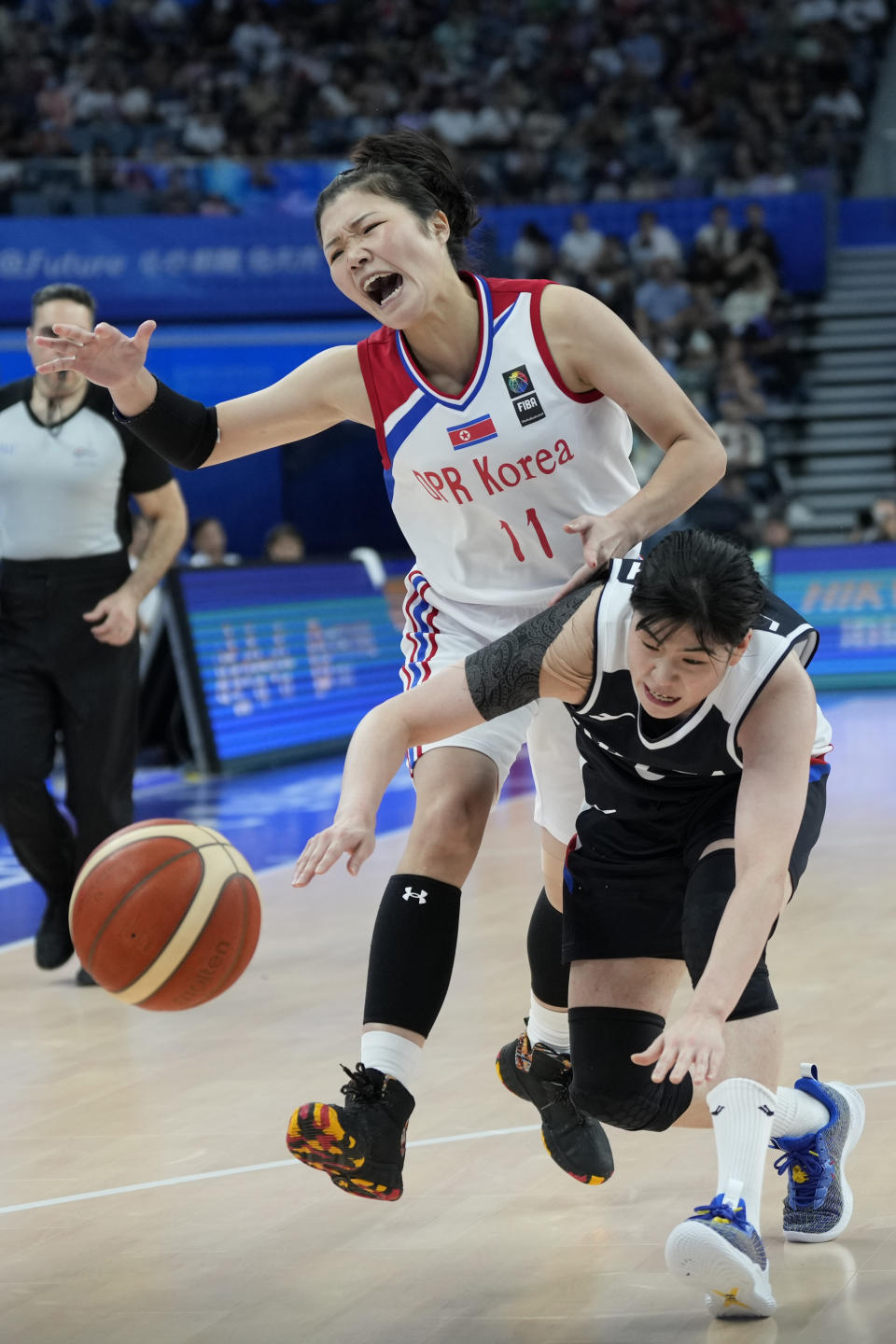 North Korea's forward Kim Ryujong (11) battles for the possesion of the ball against South Korea's guard Lee So-hee (6) during the women's basketball bronze medal match between North Korea and South Korea at the 19th Asian Games in Hangzhou, China, Thursday, Oct. 5, 2023. (AP Photo/Lee Jin-man)