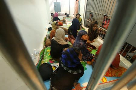 FILE PHOTO: Rohingya people are seen detained in a police station after a fishing boat carrying more than sixty Rohingya refugees was found beached at Rawi island