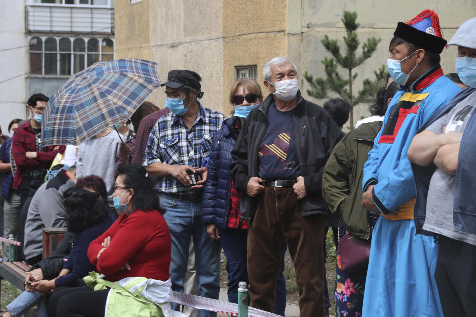 Residents wearing masks line up to cast their vote outside of the Parliamentary election district voting station no.23-9 in Bayanzurkh district of Ulaanbaatar, Mongolia on Wednesday, June 24, 2020. Mongolians were voting in parliamentary elections Wednesday across the vast, lightly populated country, a U.S. ally squeezed between authoritarian governments in China and Russia. The polls are being held amid considerable success in the country's fight against the coronavirus, with just 215 cases of COVID-19 recorded. All of them have been imported and no one has died. (AP Photo/Ganbat Namjilsangarav)