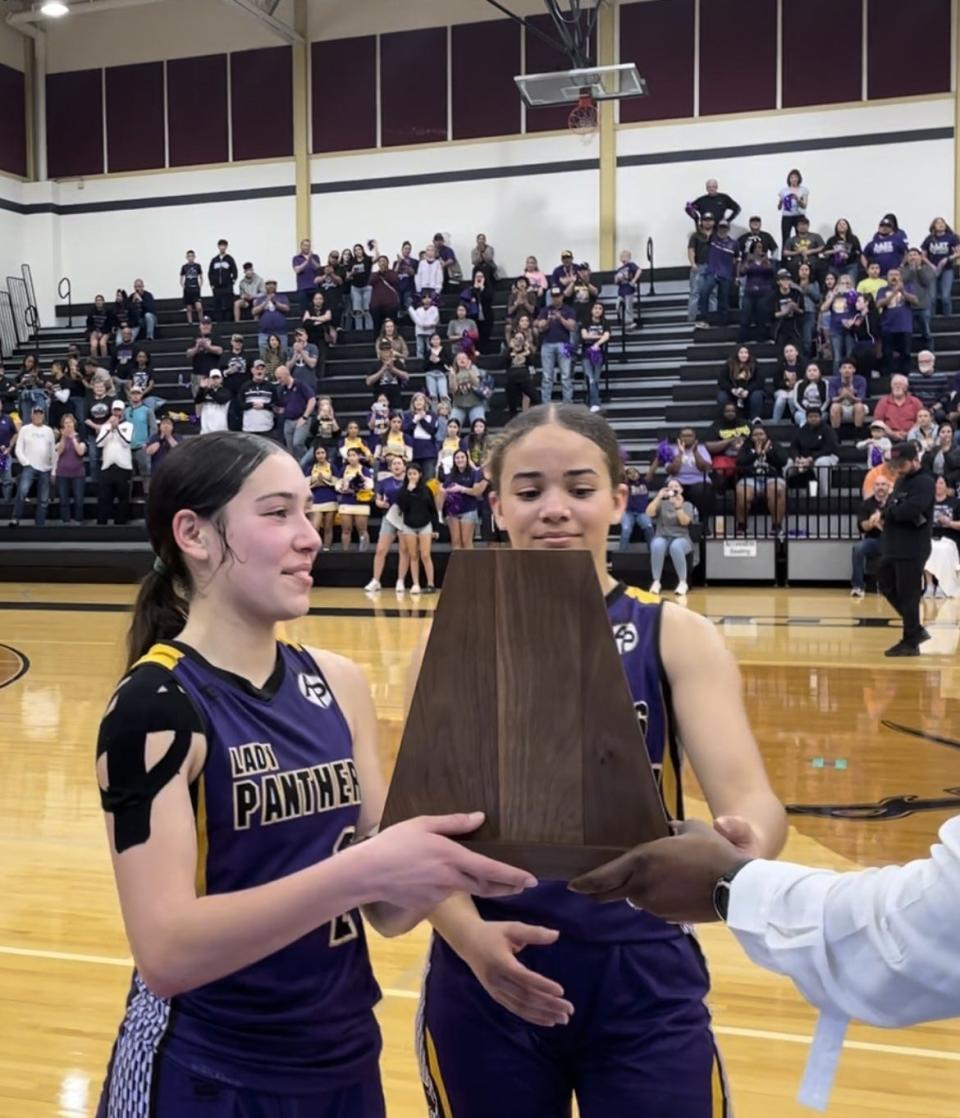 Aransas Pass seniors Jocelyn Cole and Elora Pierre receive the Region IV-3A finalist trophy following Saturday's game against Columbus in Seguin.