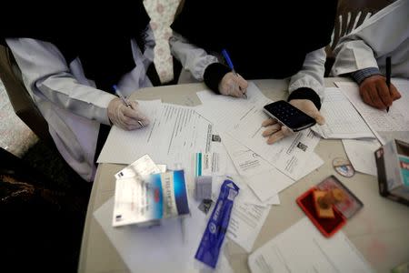 Health workers do paperwork as they receive people with suspected infection of cholera at a cholera treatment center in Sanaa, Yemen, June 27, 2017. REUTERS/Khaled Abdullah