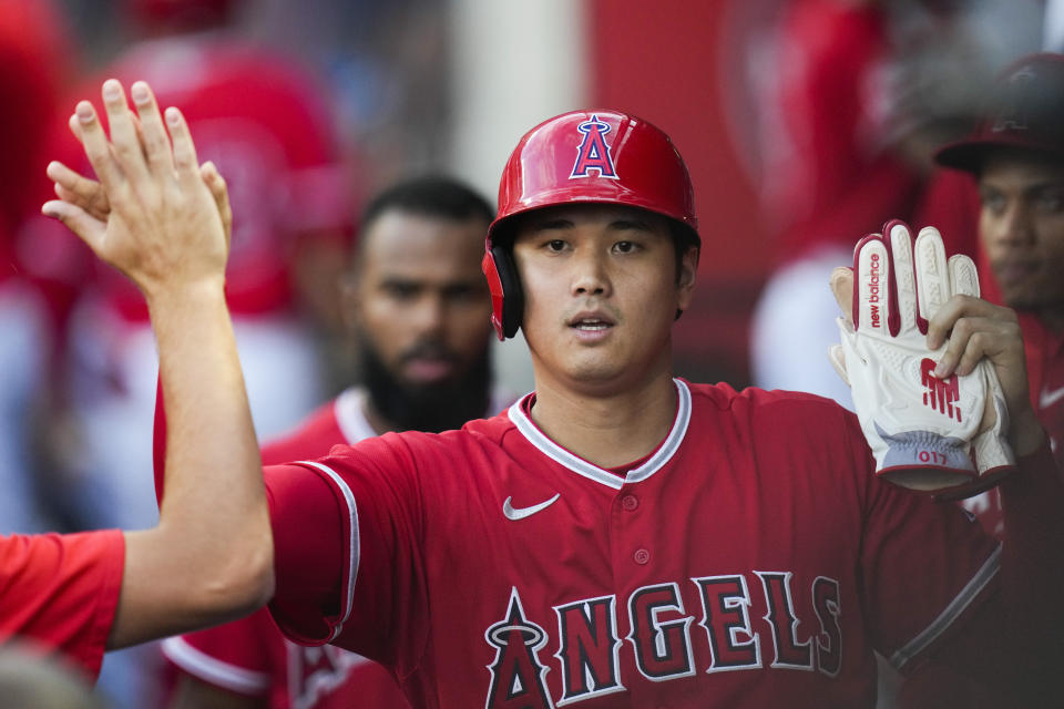 Los Angeles Angels designated hitter Shohei Ohtani (17) celebrates in the dugout after scoring off of a single hit by Mike Moustakas during the first inning of a baseball game against the San Francisco Giants in Anaheim, Calif., Tuesday, Aug. 8, 2023. (AP Photo/Ashley Landis)