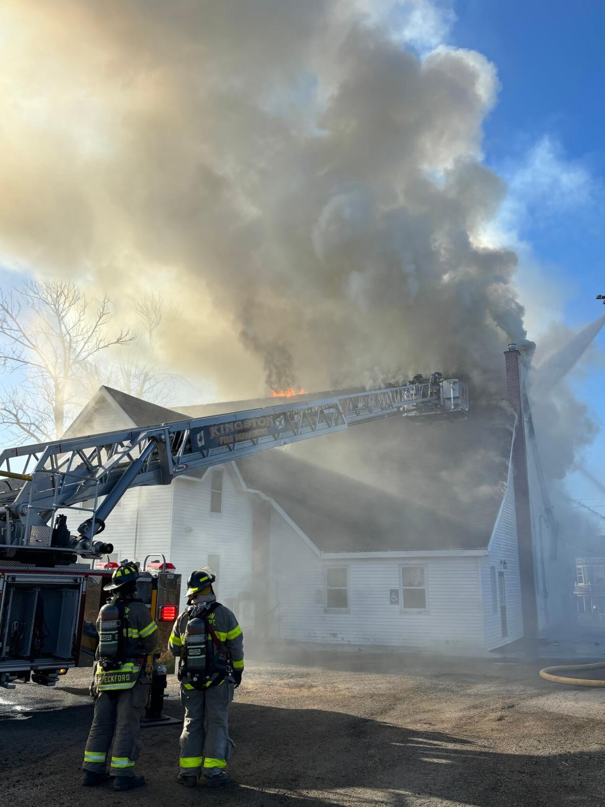 Firefighters look on as smoke billows from Bridgetown Baptist Church in Bridgetown, N.S., on Friday morning. (Andrew Cranton - image credit)