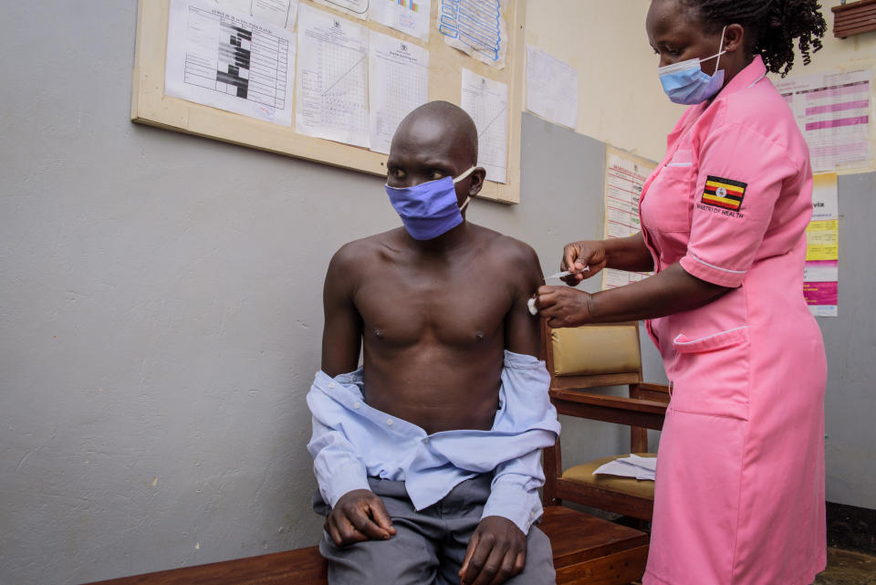 A man receives a shot of the Chinese-made Sinovac vaccine for coronavirus at Aywee health center in the Gulu district of Uganda Thursday, Sept. 23, 2021. Repeated and sudden power failures plague the vaccine storage unit, adding to the logistical challenges facing efforts to ramp up vaccination across the country. (AP Photo/Nicholas Bamulanzeki)