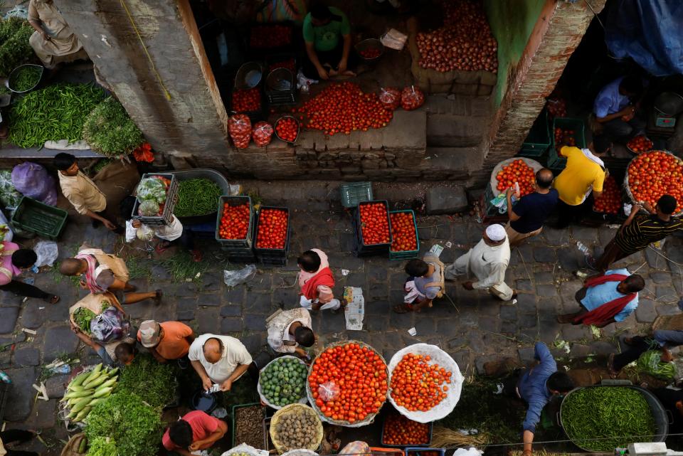 People shop at a crowded wholesale vegetable market in Delhi’s old quarter after authorities eased coronavirus restrictions following a drop in infections (REUTERS)