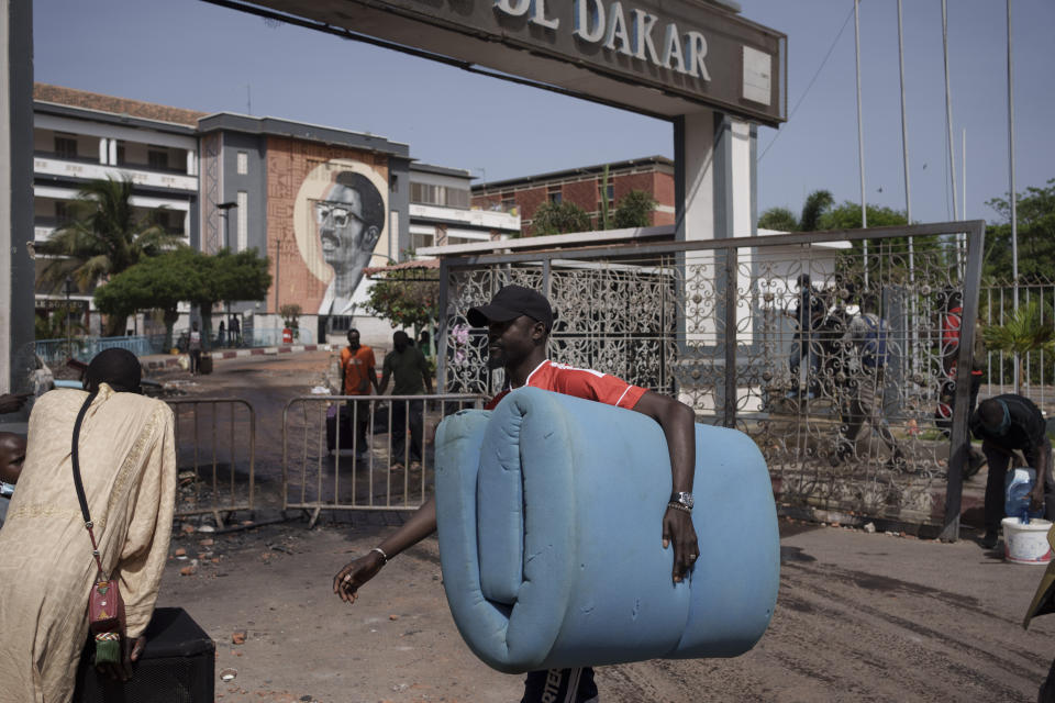 Carrying a mattress a student leaves the Cheikh Anta Diop University after authorities ordered the institution to be closed until further notice in Dakar, Senegal, Friday, June 2, 2023. Clashes between police and supporters of Senegalese opposition leader Ousmane Sonko left nine people dead, the government said Friday, with authorities issuing a blanket ban on the use of several social media platforms in the aftermath of the violence. (AP Photo/Leo Correa)