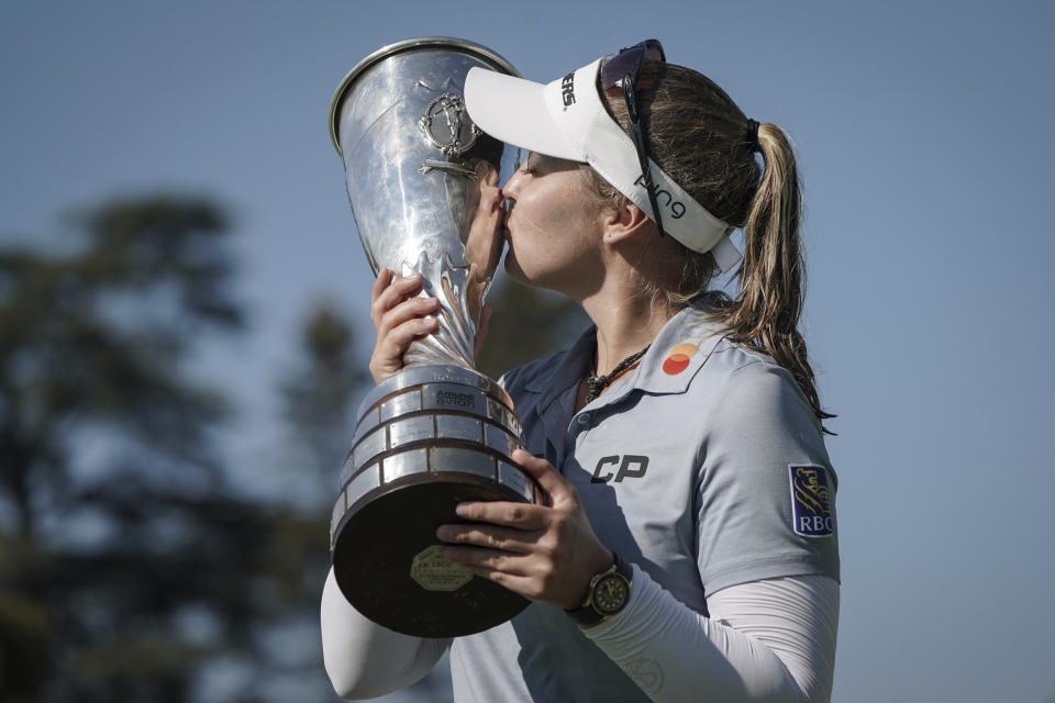 Brooke Henderson, of Canada, kisses with her trophy after winning the Evian Championship women's golf tournament in Evian, eastern France, Sunday, July 24, 2022. (AP Photo/Laurent Cipriani)