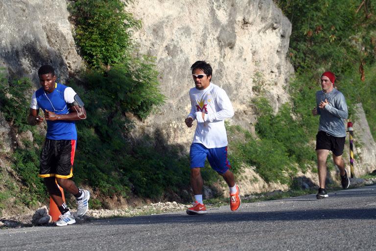 Manny Pacquiao (centre) runs along a highway during training in General Santos City on the southern island of Mindanao on October 24, 2013