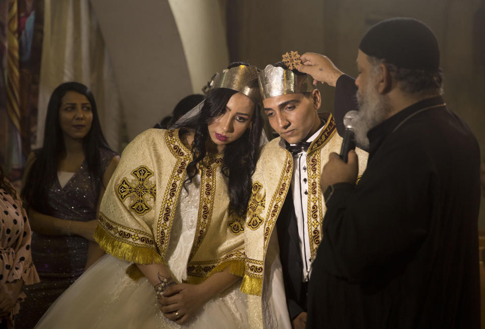 In this June 15, 2019, photo, a Coptic priest blesses an Egyptian couple during their wedding in St. Samaan's Church, in the predominantly Christian Manshiyat Nasser area of Cairo. Egypt’s legal system grants the Coptic church full authority over personal status matters of Copts, namely marriage and divorce. But the church does not have the same powers over its followers’ inheritance rights. (AP Photo/Maya Alleruzzo)