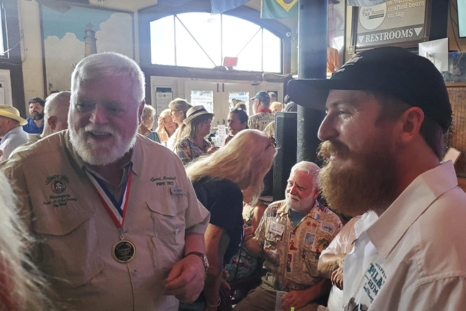 Stephen Hemingway Adams, derecha, bisnieto de Ernest Hemingway, habla con el ganador del Concurso de imitaciones de Hemingway 2023, Gerrit Marshall, en el Sloppy Joe's Bar en Key West, Florida, el miércoles 17 de julio de 2024. (Foto AP/David Fischer)