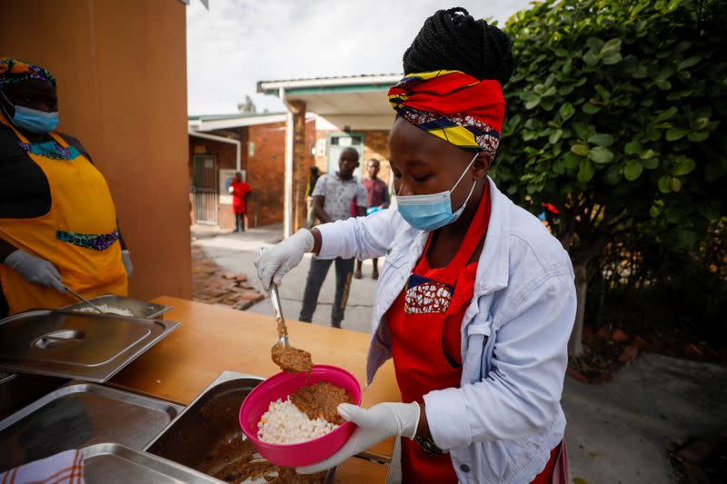 Volunteers and teachers serve food at a school feeding scheme in Gugulethu township during a nationwide lockdown aimed at limiting the spread of coronavirus disease (COVID-19) in Cape Town