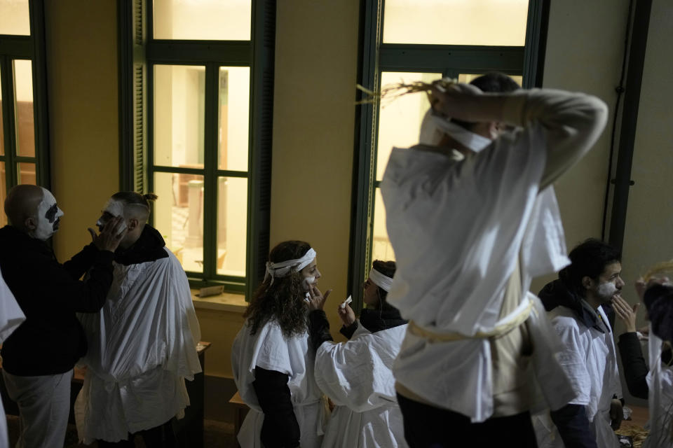 Young men and women prepare for the Torch Parade (Lampadiforia) on the Aegean Sea island of Naxos, Greece, late Saturday, Feb. 25, 2023. The first proper celebration of the Carnival after four years of COVID restrictions, has attracted throngs of revellers, Greek and foreign, with the young especially showing up in large numbers. (AP Photo/Thanassis Stavrakis)