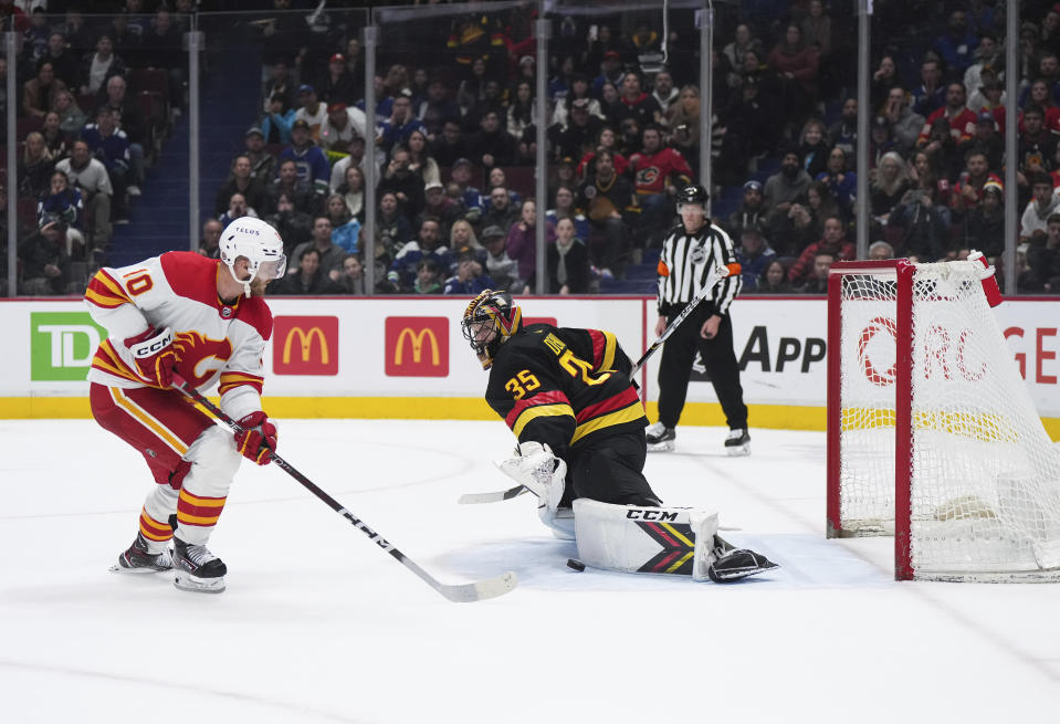 Vancouver Canucks goalie Thatcher Demko (35) stops Calgary Flames' Jonathan Huberdeau (10) during the shootout in an NHL hockey game Saturday, April 8, 2023, in Vancouver, British Columbia. (Darryl Dyck/The Canadian Press via AP)