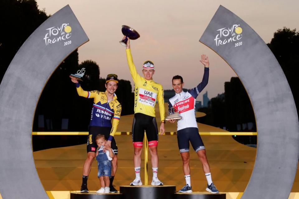 Overall winner Tadej Pogacar, wears the yellow jersey in Paris in between second-placed Primoz Roglic and third-placed Porte.