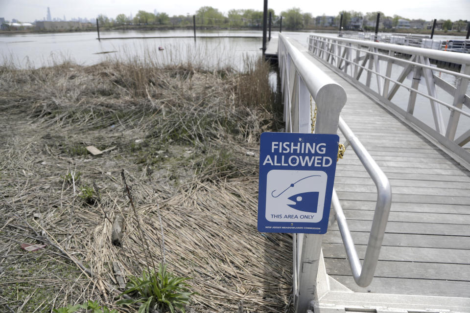 FILE - A fishing sign hangs on a walkway along the banks of the Hackensack River at New Jersey Meadowlands Commission's River Barge Park, April 25, 2019, in Carlstadt, N.J. Sediment in a 19-mile stretch of the Hackensack River in northern New Jersey has traces of arsenic, lead and other contaminants and is being named as a U.S. Environmental Protection Agency's Superfund site, federal and state regulators said Thursday. (AP Photo/Julio Cortez, File)