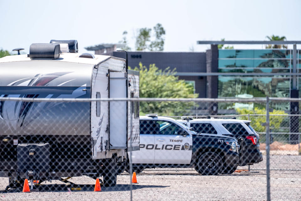 Police officers sit in their vehicles at the Tempe Resource Village as unhoused individuals, advocates and legal observers gather near a homeless encampment along the Rio Salado riverbed in Tempe on Aug. 31, 2022. Tempe gave notice for people living in the river bottom to vacate by Aug. 31.