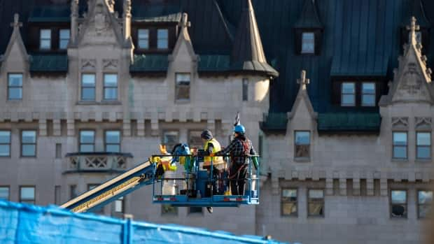 Construction workers are moved into place near Parliament Hill's East Block earlier this week.  (Andrew Lee/CBC - image credit)