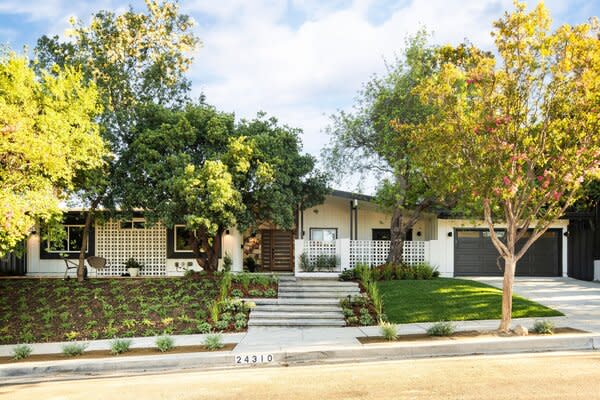 Located in L.A.'s Woodland Hills neighborhood, the home rests on a quiet street nestled among soaring trees. A tall fence bordering the property offers plenty of privacy.