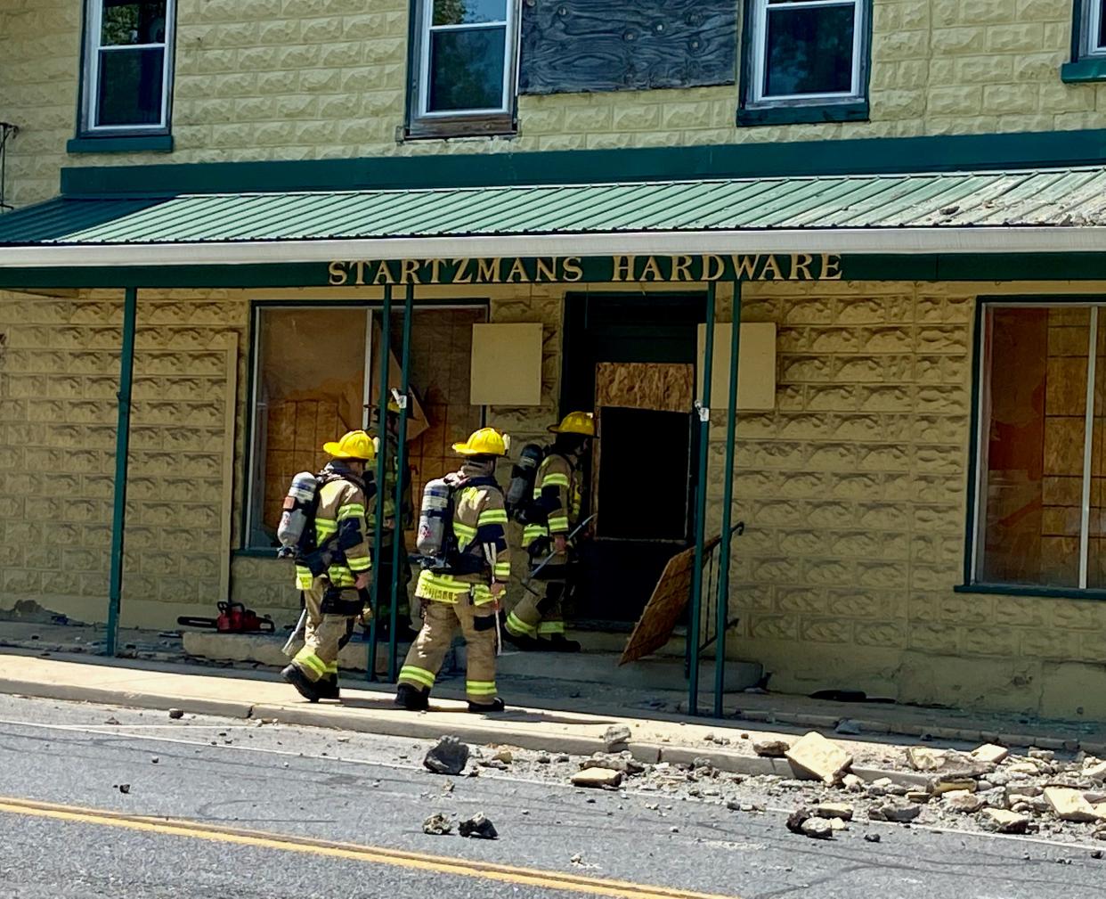 Hagerstown firefighters check out the former Startzman's Hardware store in the 700 block of South Potomac Street after part of the facade collapsed Sunday onto the street and sidewalk.