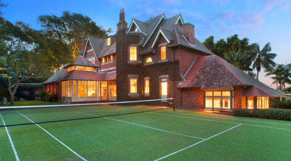 A warm glow from inside the eight-bedroom home lights up the tennis court as the sun goes down.