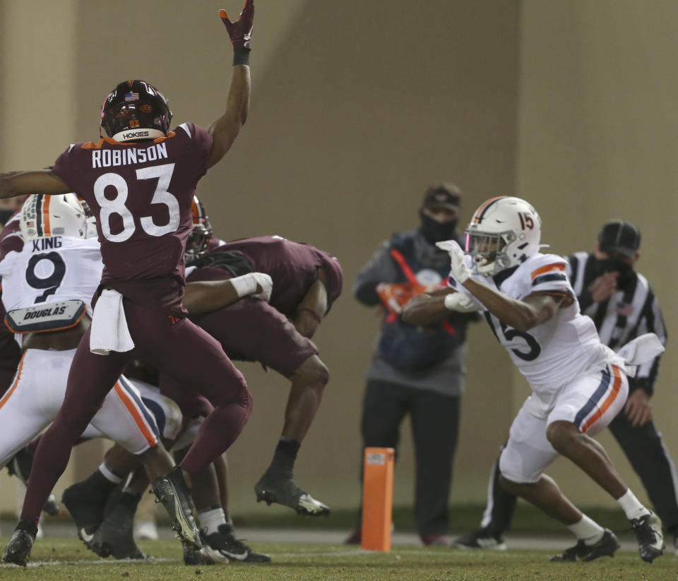 Virginia Tech's Tré Turner, second from right, scores a touchdown against Virginia during the first half of an NCAA college football game Saturday, Dec. 12, 2020, in Blacksburg, Va. (Matt Gentry/The Roanoke Times via AP, Pool)