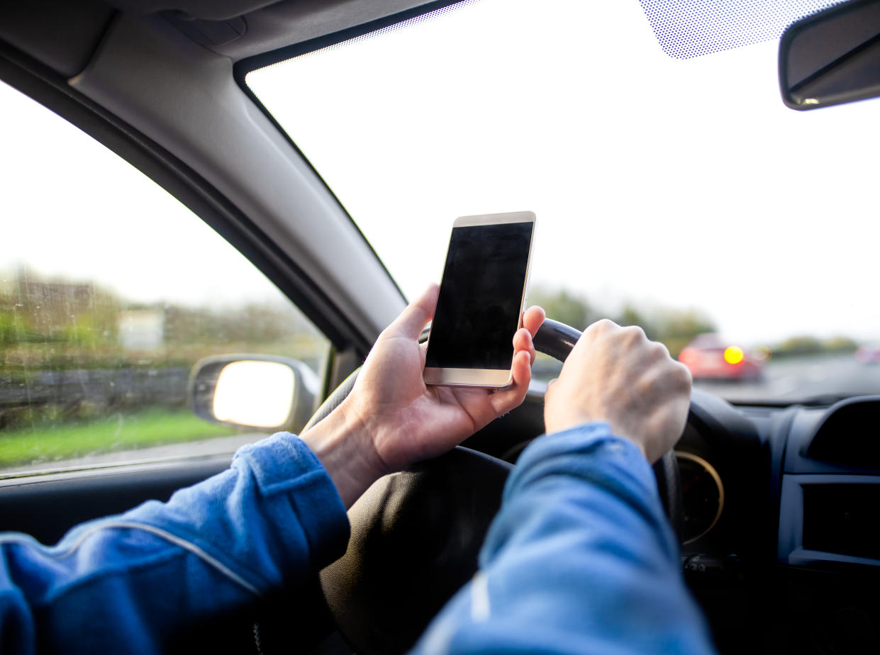 Man using smartphone whilst driving