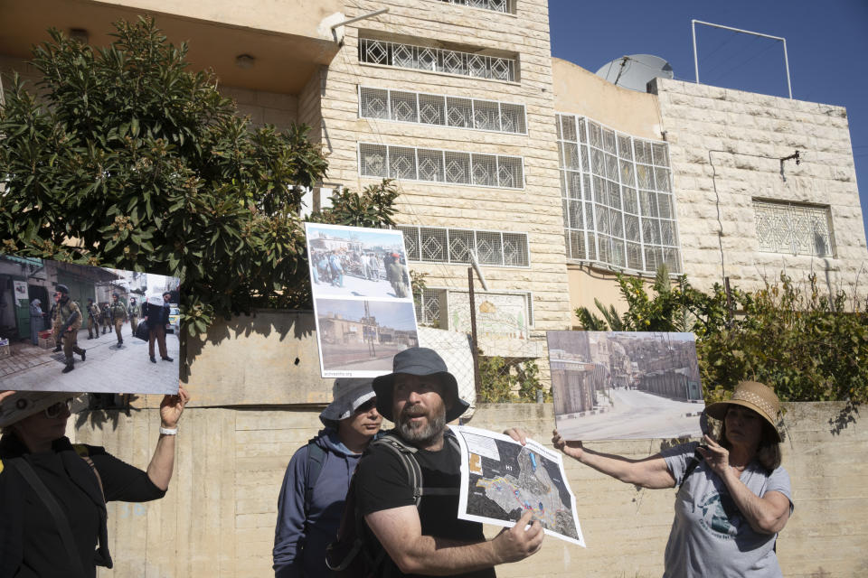 An Israeli activist gives a tour of the embattled West Bank city of Hebron, Friday, Dec. 2, 2022. Israeli peace activists toured the occupied West Bank's largest city Friday in a show of solidarity with Palestinians, amid chants of "shame, shame" from ultra-nationalist hecklers. The encounter in the center of Hebron signaled the widening rift among Israelis over the nature of their society and Israel's open-ended military rule over the Palestinians, now in its 56th year. (AP Photo/ Maya Alleruzzo)