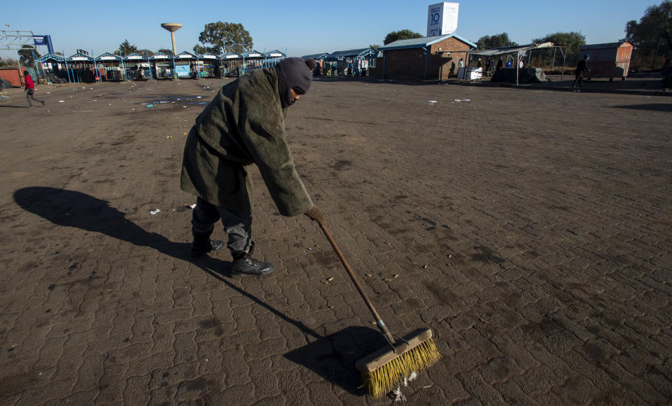 A worker sweeps the floor at a taxi rank in Katlehong, South Africa, Monday, June 22, 2020, as taxi drivers affiliated to the SA National Taxi Council (Santaco) protested against what it believes to be insufficient government relief offered to the industry. South Africa’s largest city, Johannesburg, has been hit by a strike by mini-bus taxis, preventing many thousands of people from getting to work on Monday, as the country reopens its economy even as cases of COVID-19 are increasing. (AP Photo/Themba Hadebe)