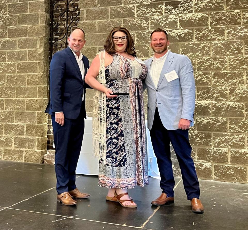 The Julia Tucker Award is presented to Joslynn Fish and South Press coffeeshop by Positively Living and Choice Health Network CEO Steve Jenkins and board president Tate Coffey.