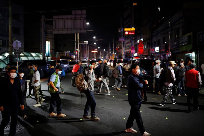 Day workers cross a road as they gather to seek for a job amid the coronavirus disease (COVID-19) pandemic in Seoul