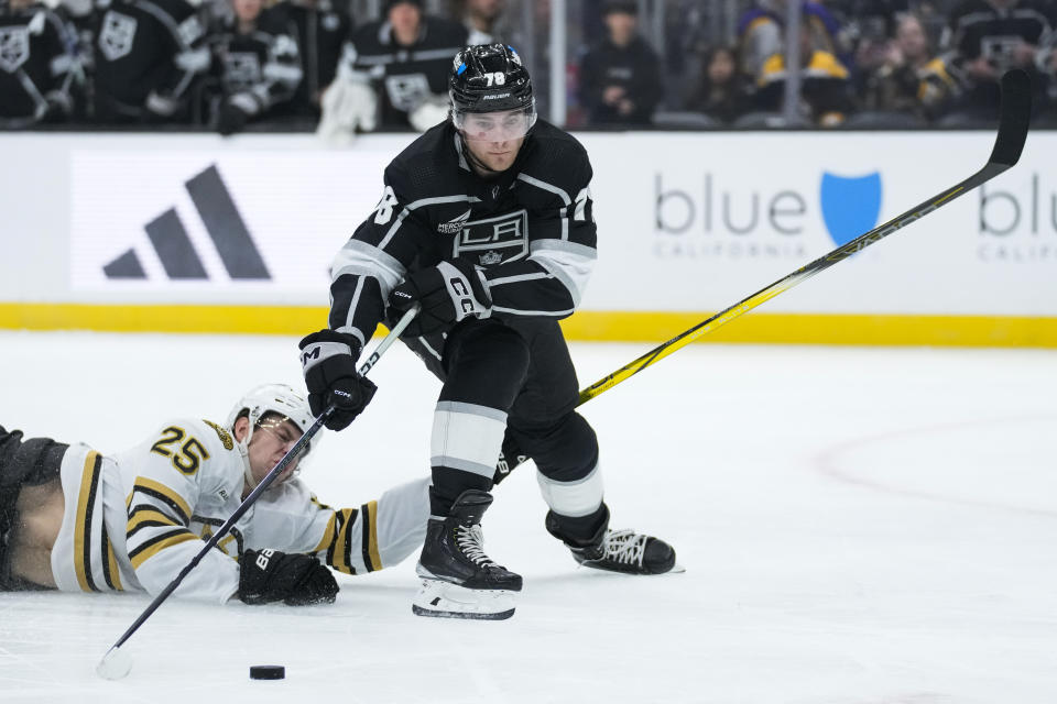 Los Angeles Kings right wing Alex Laferriere (78) shoots and scores against Boston Bruins defenseman Brandon Carlo (25) during the second period of an NHL hockey game Saturday, Oct. 21, 2023, in Los Angeles. (AP Photo/Ashley Landis)