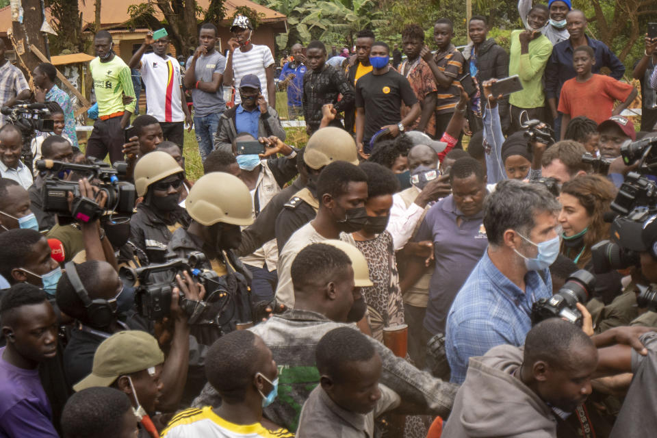 Uganda's leading opposition challenger Bobi Wine and his wife, centre, leave the polling station after voting in Kampala, Uganda, Thursday, Jan. 14, 2021. Ugandans are voting in a presidential election tainted by widespread violence that some fear could escalate as security forces try to stop supporters of Wine from monitoring polling stations.(AP Photo/Jerome Delay)