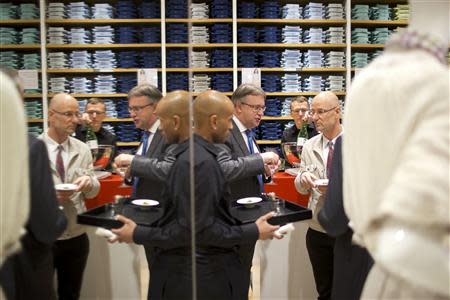 People stand in the Uniqlo Global flagship store during a preopening in Berlin, April 10, 2014. REUTERS/Axel Schmidt