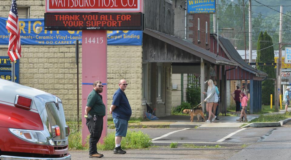 Wattsburg Hose Co. Capt. Chris Evans, left, and Chief Marty Hamilton pay their respects as the funeral procession for Jacques "Jay" F. Rougeau Jr., a Pennsylvania State Police trooper who was fatally shot while on duty in central Pennsylvania, passes north through Wattsburg, Pa., on Monday. Viewing and the funeral for Rougeau will take place at the Bayfront Convention Center in Erie.