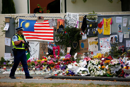 A policeman walks next to a makeshift memorial outside of the Al Noor Mosque in Christchurch, New Zealand March 21, 2019. REUTERS/Edgar Su