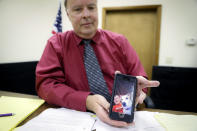 Jackson County Municipal Court Judge Mark T. Musick displays an image of Brandon, a young man he helped raise as a son, as he sits at his bench, Wednesday, July 17, 2019, in Jackson, Ohio. Musick presides over the local drug court in an area heavily damaged by the opioid epidemic. The image was sent by Brandon hours before his fatal overdose on opioids and serves as the home screen image on the judge's phone. (AP Photo/John Minchillo)