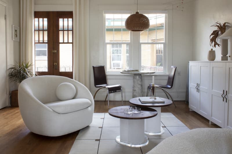 Living area with rounded white chair and sitting area by window