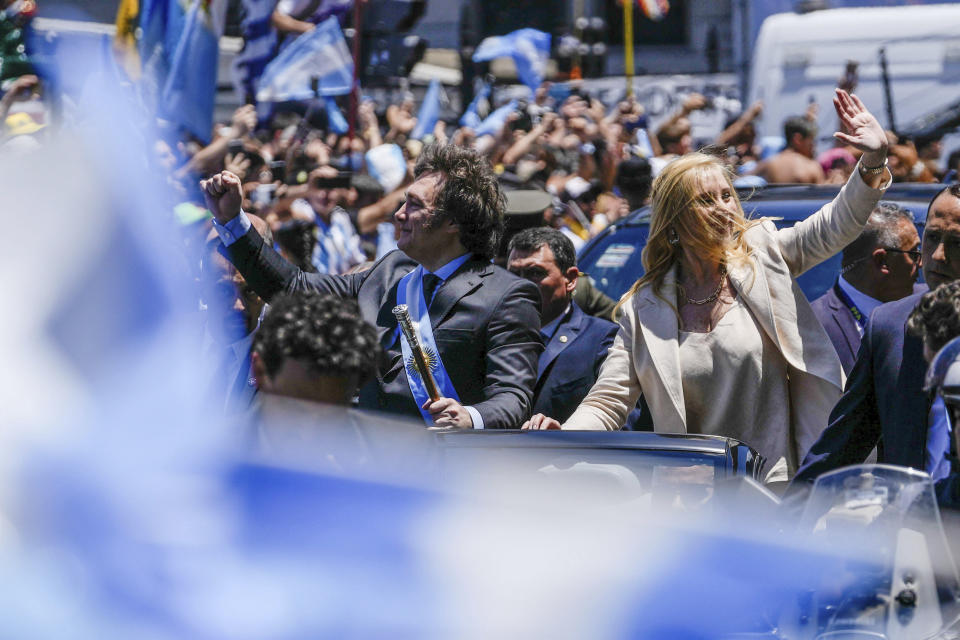 Argentina's newly sworn-in President Javier Milei and his sister Karina wave to supporters from a car heading to the government house after his swearing-in ceremony in Buenos Aires, Argentina, Sunday, Dec. 10, 2023. (AP Photo/Rodrigo Abd)